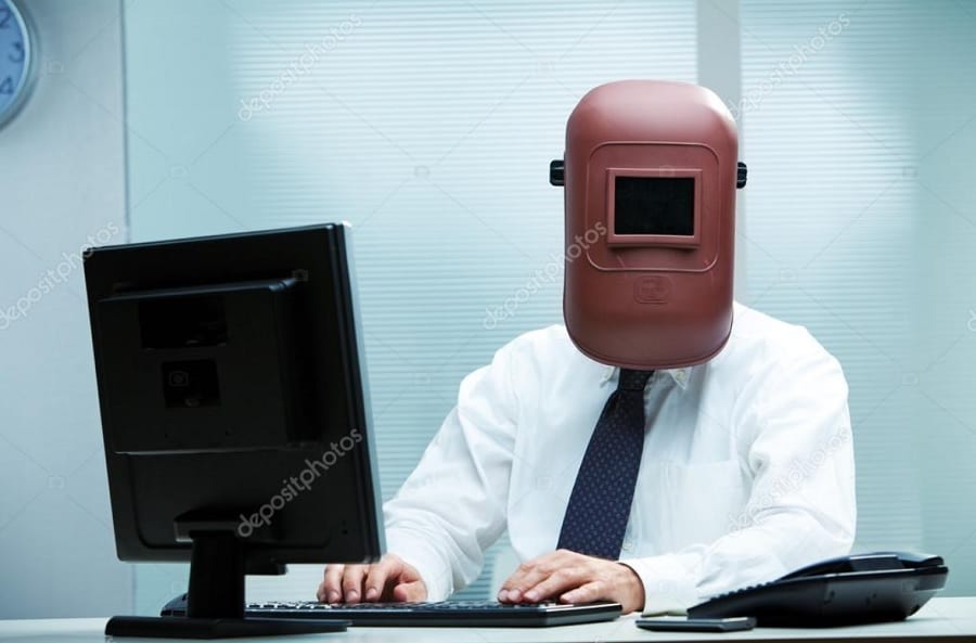 weird stock photos man in welders mask at desk