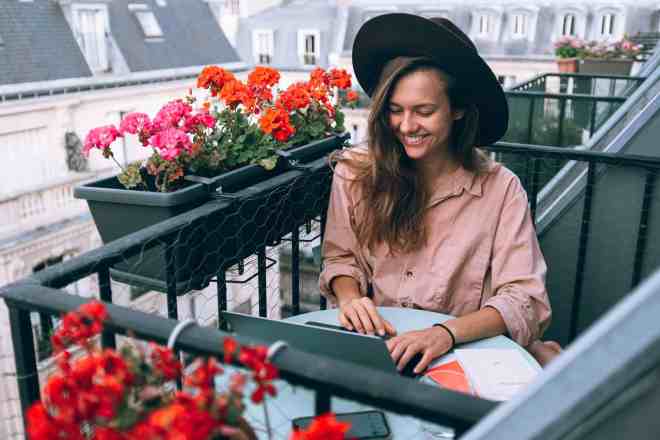 woman on balcony with laptop