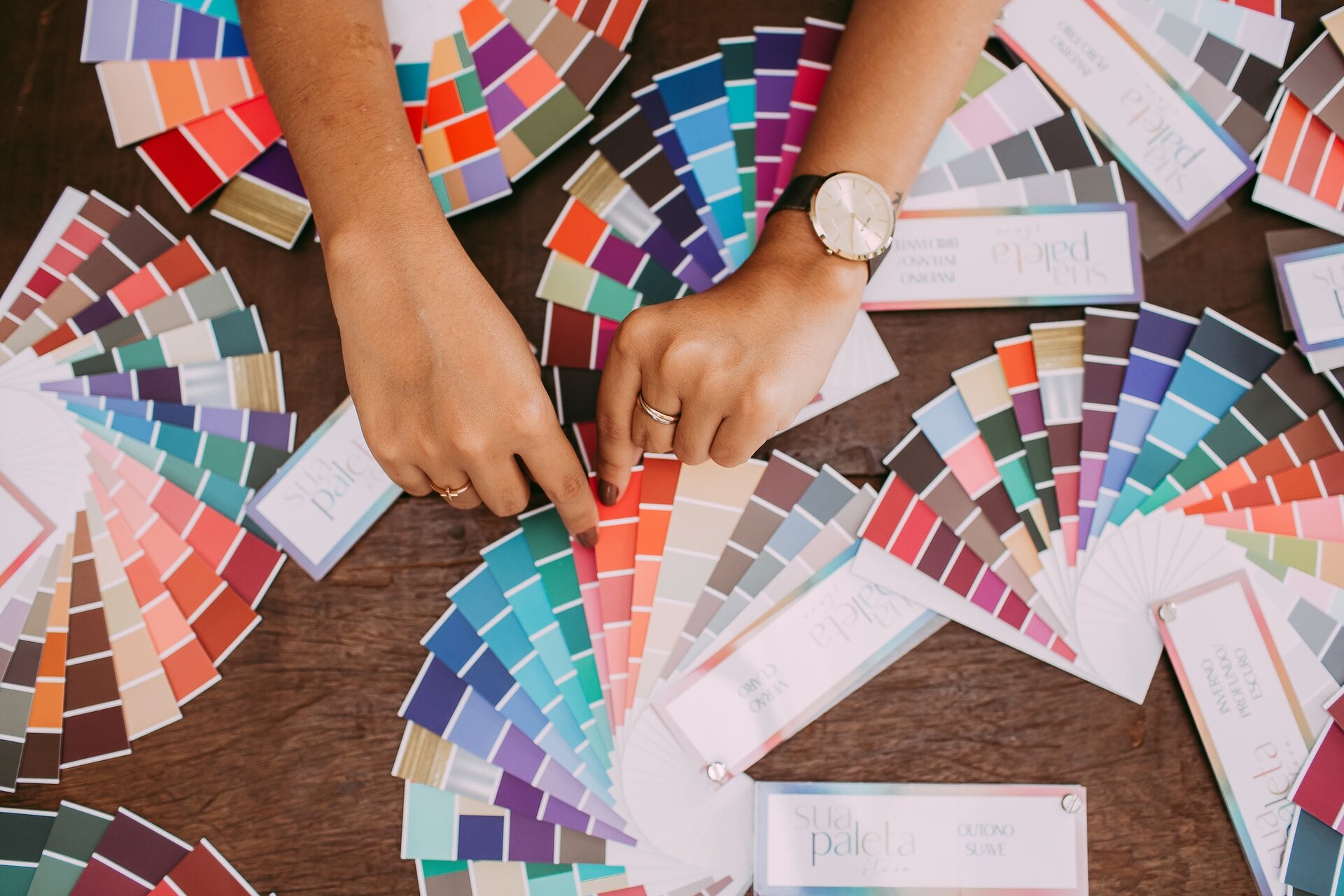 Person choosing among color swatches on a table